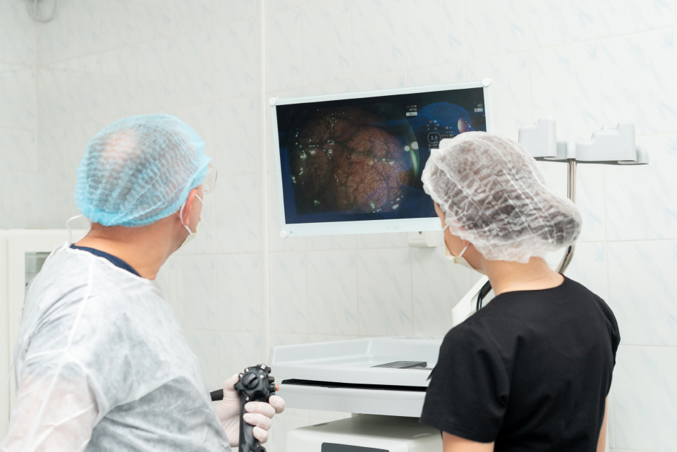 Colorectal surgeon performing a colonoscopy on a patient